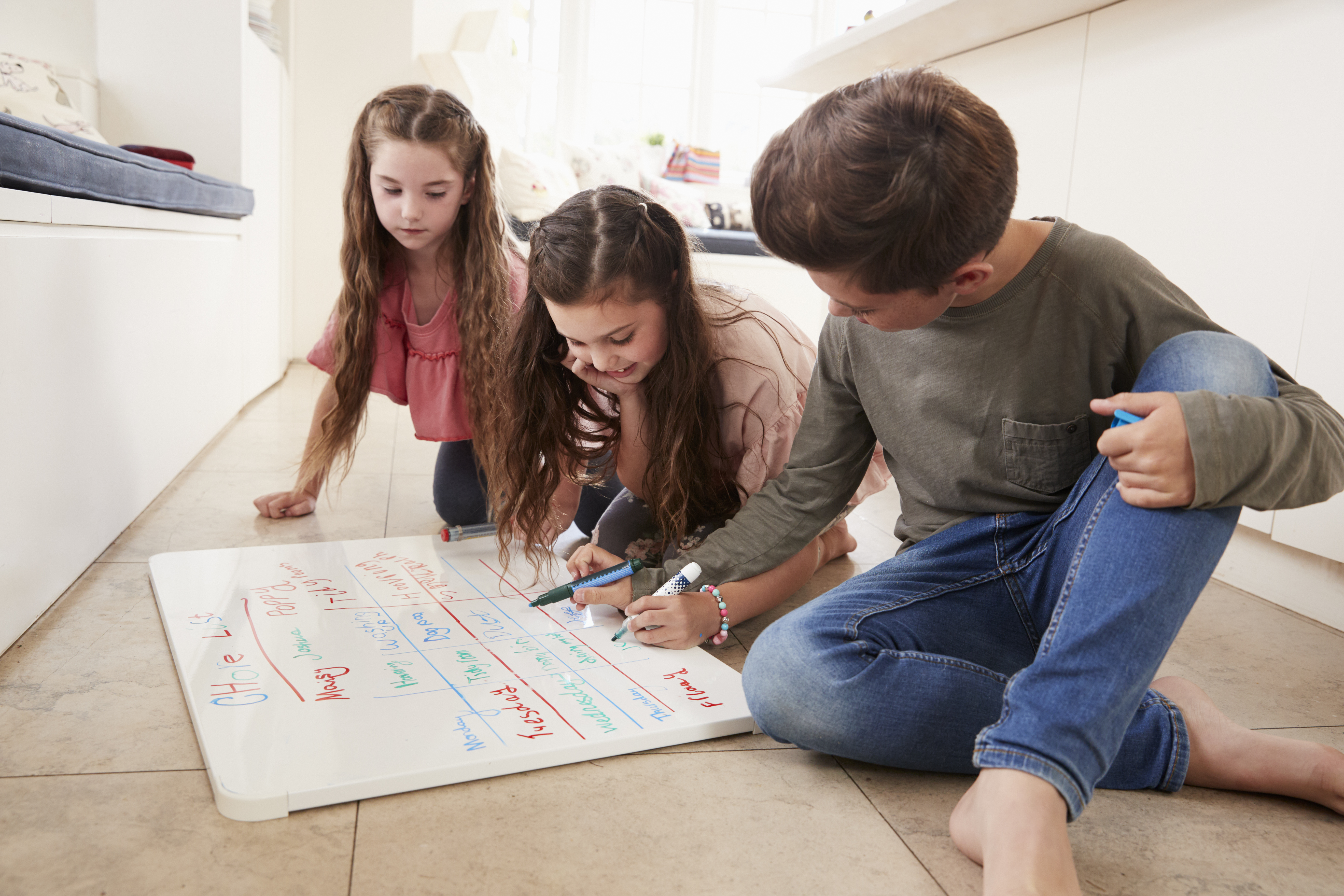 Familie plant gemeinsam den Wochenplan auf einer Tafel